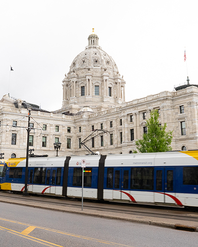 A light rail train passes outside the Minnesota State Capitol building in Saint Paul.