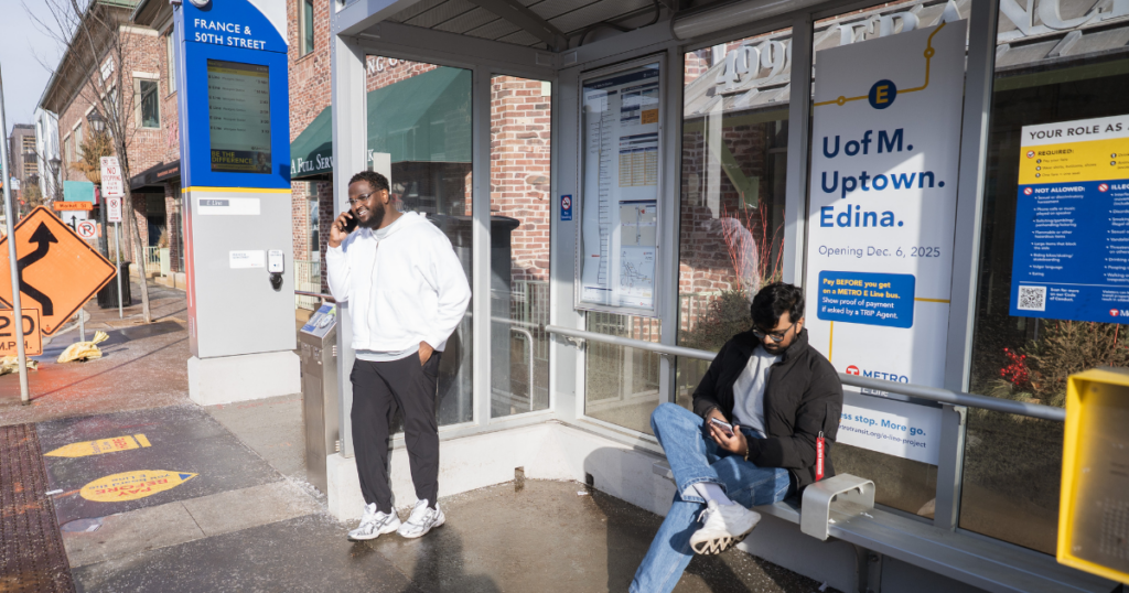 Two people wait at a Metro Transit bus stop in the Twin Cities, MN.