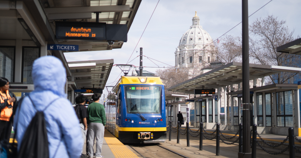 A Green Line light rail train pulls into a station near the Minnesota Capitol